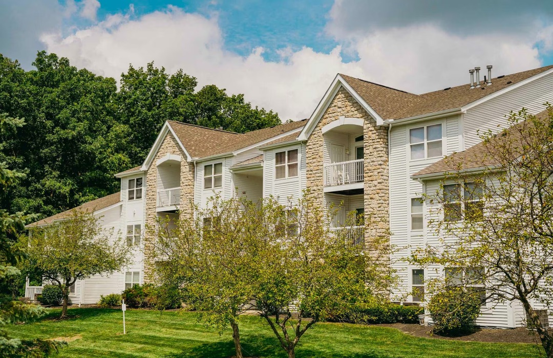 a building with multiple levels with trees behind and in front of it