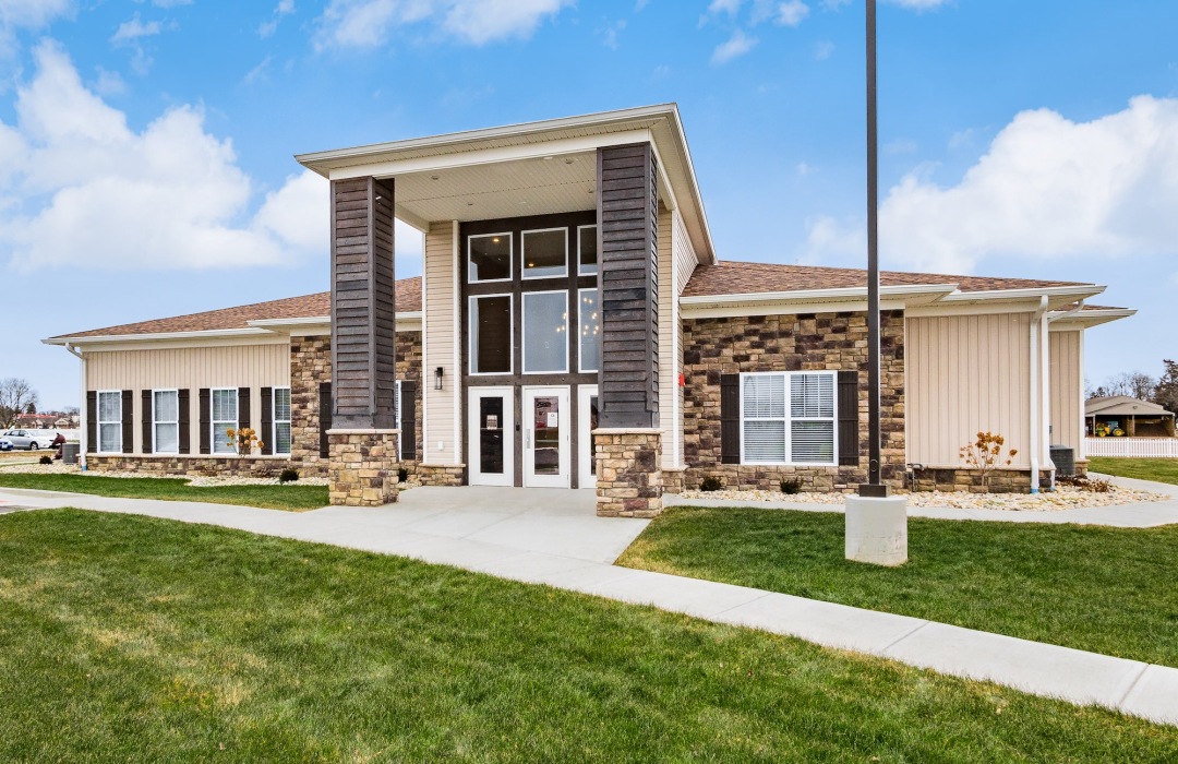 a building with grass and a light pole in front of it