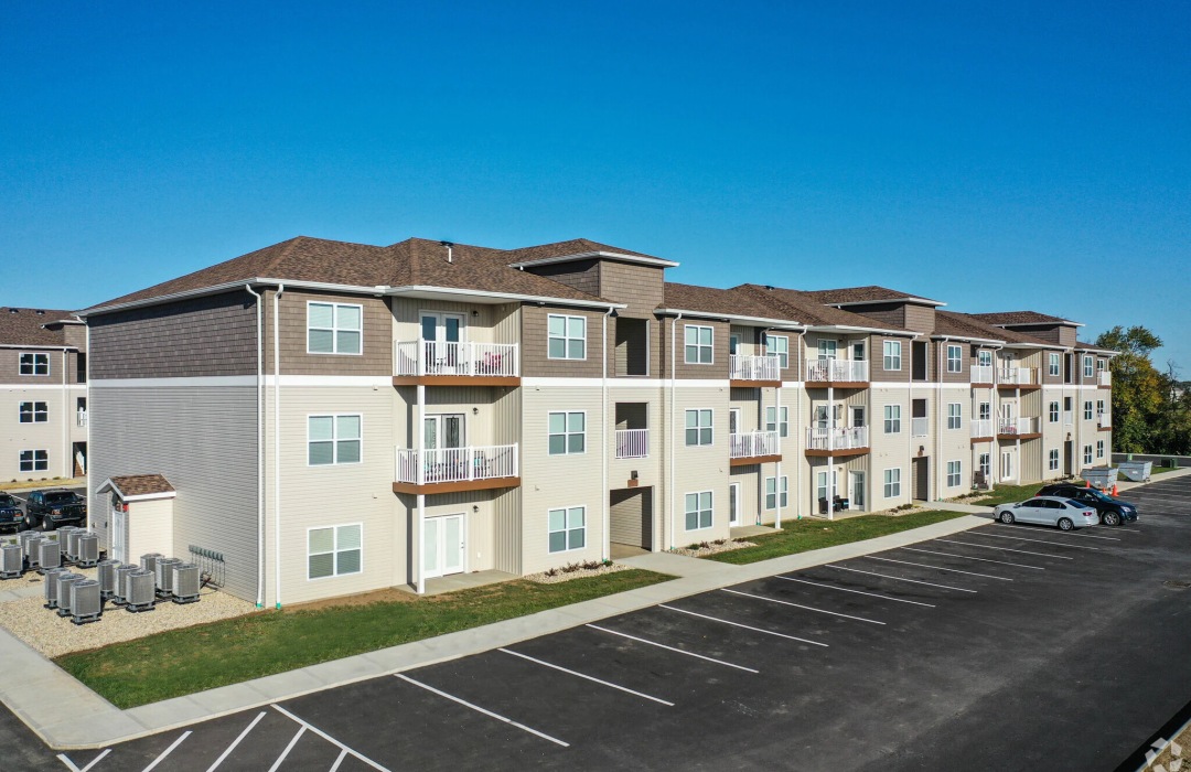 a large building with many windows and a parking lot in front of it