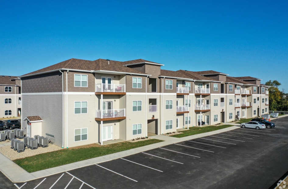 a large building with many windows and a parking lot in front of it