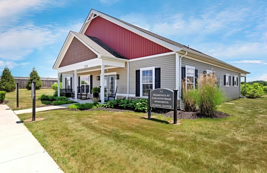 a building with a sign and grass in front of it