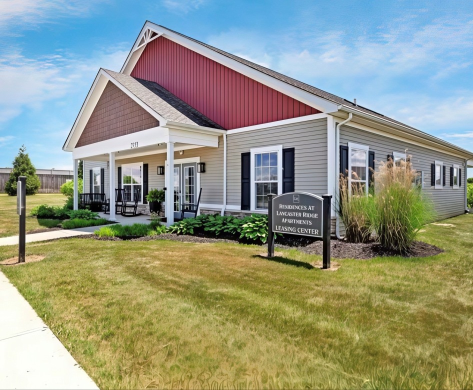 a building with a sign and grass in front of it