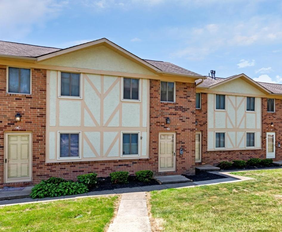 a brick building with sidewalk and landscaping
